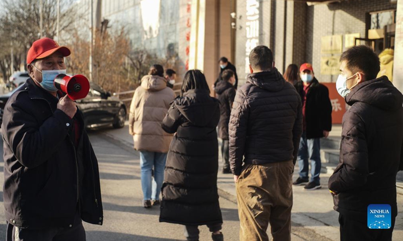 A staff member instructs as people line up for nucleic acid test in Songzhuang Township, Tongzhou District of Beijing, capital of China, Dec. 20, 2021. Beijing Municipality reported one new locally transmitted confirmed COVID-19 case on Sunday, the city's health commission said Monday. (Photo:Xinhua)