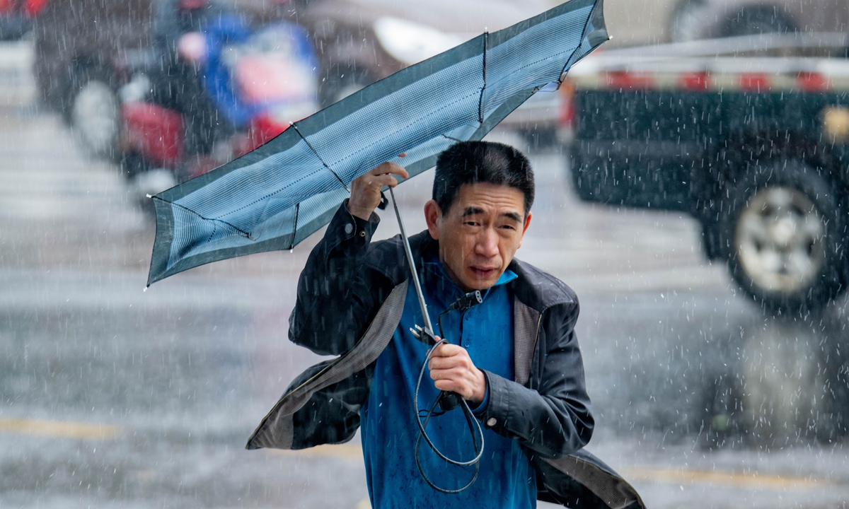 A resident in Qionghai, South China's Hainan Province, holds an umbrella walking in heavy rain on December 20, 2021, as Typhoon Rai approaches the province. Hainan issued a level III sea wave alert that day and nearly 500 residents in the city of Sansha have been evacuated. Photo: VCG