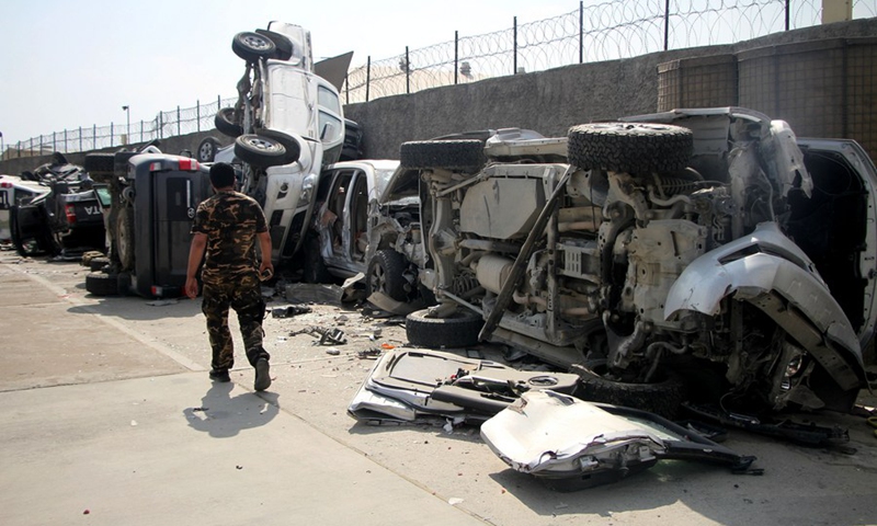 A Taliban member walks past damaged vehicles at the Kabul airport in Kabul, capital of Afghanistan, Sept. 20, 2021. The Kabul airport was damaged with its many facilities destroyed during the withdrawal of the last U.S.-led forces and U.S.-led evacuation flights in late August.(Photo: Xinhua)