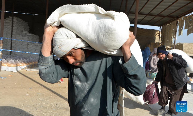 Local people receive relief food assistance donated by World Food Program (WFP) in Kandahar city, southern Afghanistan, Dec. 20, 2021.(Photo: Xinhua)