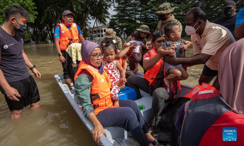 Rescuers evacuate flood victims in Shah Alam, Selangor, Malaysia, Dec. 20, 2021. Eight people have been reported dead due to severe flooding in Malaysia as of Monday, authorities in Selangor state said.(Photo: Xinhua)