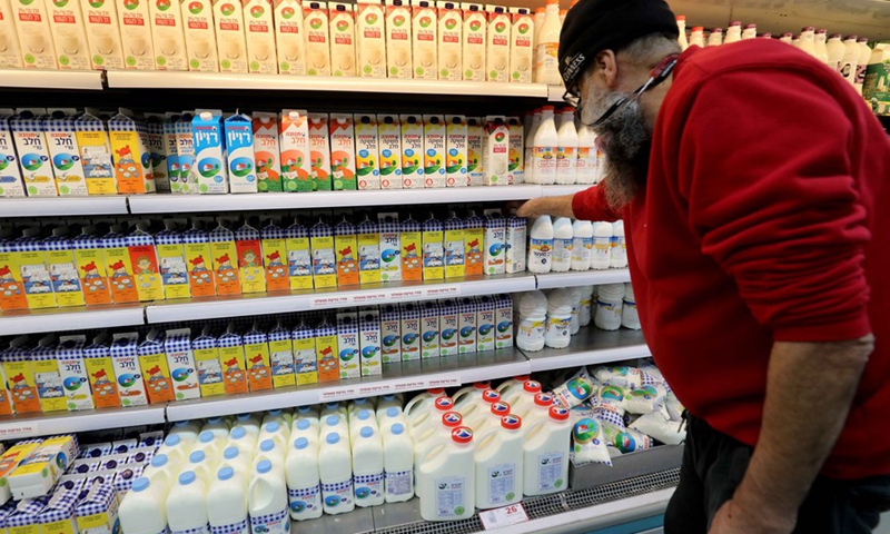 A staff arranges cartons of milk, which are printed with Hebrew words, at a supermarket in central Israeli city of Modiin on Dec. 21, 2021.(Photo: Xinhua)