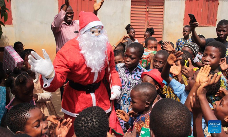 A man dressed as Santa Claus visits children in a private school in Ouidah, Benin, Dec. 21, 2021.(Photo: Xinhua)
