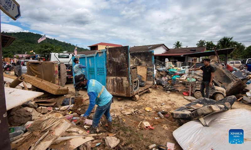 Local residents clear up mud and debris after flood hit in Hulu Langat of Selangor state, Malaysia, Dec. 21, 2021. Another nine people have been reported dead, bringing the total deaths due to severe flooding in Malaysia to 17 as of Tuesday, authorities in Selangor state said.(Photo: Xinhua)