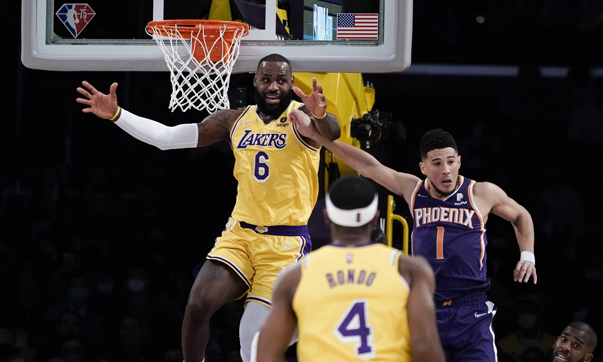 Los Angeles Lakers' LeBron James (left) reacts after missing a basket under pressure from Phoenix Suns' Devin Booker (right) on December 21, 2021 in Los Angeles. Photo: VCG