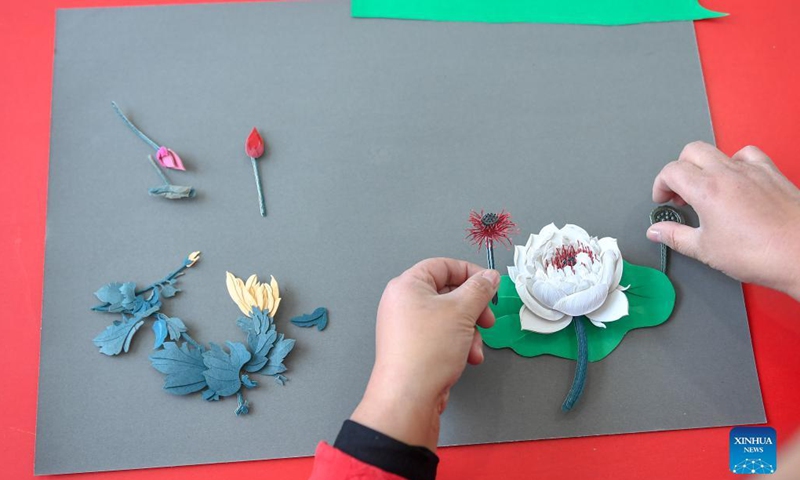 Li Baofeng creates works of paper cutting in Changchun, northeast China's Jilin Province, Dec. 17, 2021. Li Baofeng, 56, is a paper cutting artist in Jilin. Combining traditional paper cutting technique with features of various painting forms like the Chinese painting, oil painting and printmaking, Li creates her own art style. Her works are rich in color and strong in three-dimensional sense. Most of her creations focus on the Chinese classical literature, folk customs and landscapes.(Photo: Xinhua)