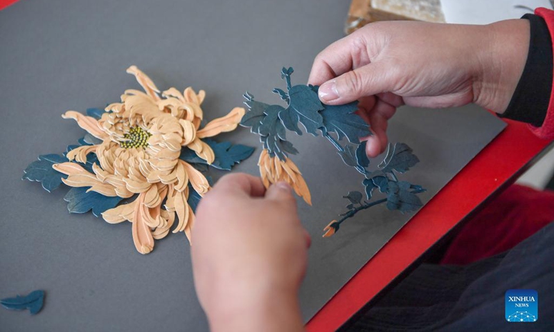 Li Baofeng creates works of paper cutting in Changchun, northeast China's Jilin Province, Dec. 17, 2021. Li Baofeng, 56, is a paper cutting artist in Jilin. Combining traditional paper cutting technique with features of various painting forms like the Chinese painting, oil painting and printmaking, Li creates her own art style.Her works are rich in color and strong in three-dimensional sense. Most of her creations focus on the Chinese classical literature, folk customs and landscapes.(Photo: Xinhua)