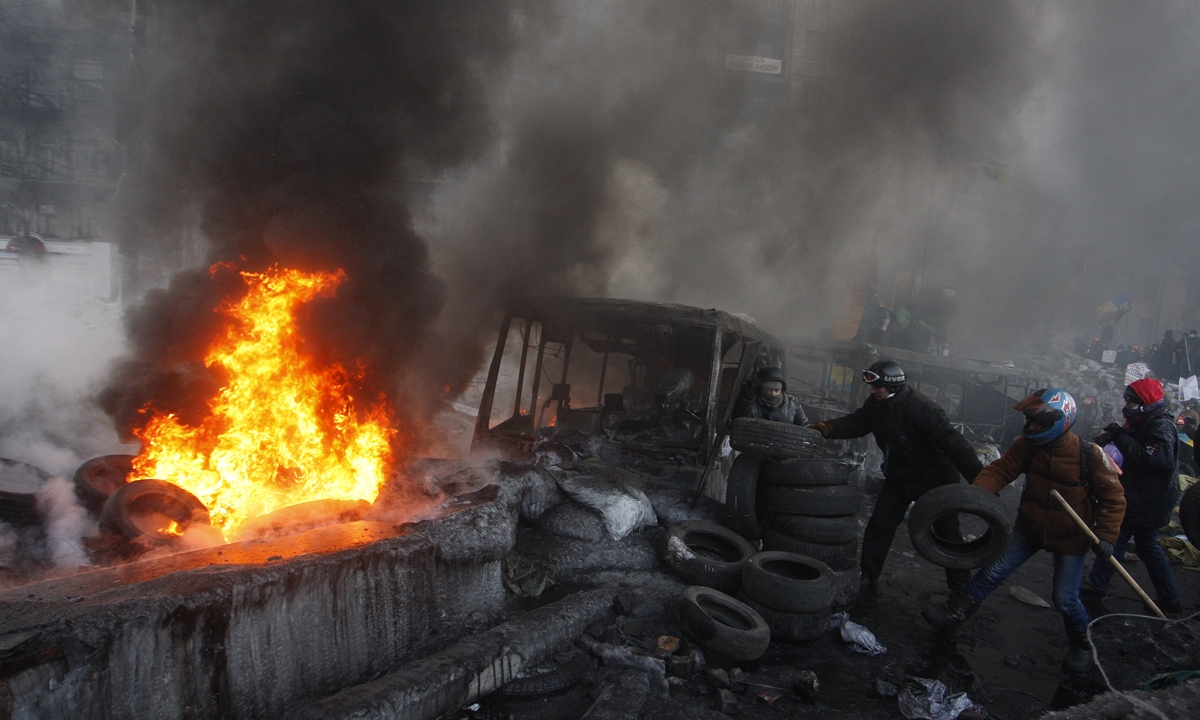 Ukrainian anti-government protesters burn tires at a site of clashes with riot police in Kiev on January 25, 2014.Photo:VCG
