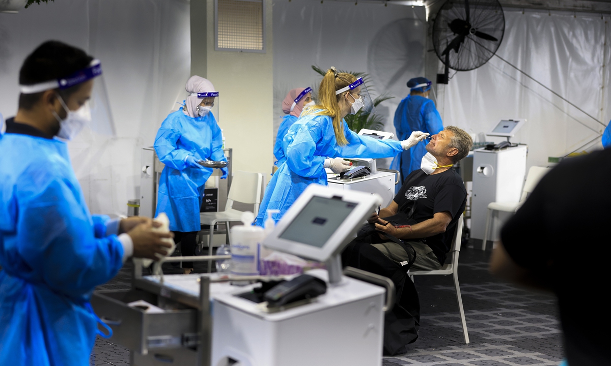 A man receives a COVID-19 test at the Histopath pre-departure clinic at Sydney International Airport in Sydney, Australia on December 23, 2021. Demand at COVID-19 testing centers across Sydney has increased in the lead-up to Christmas as New South Wales' coronavirus case numbers rise. Photo: AFP