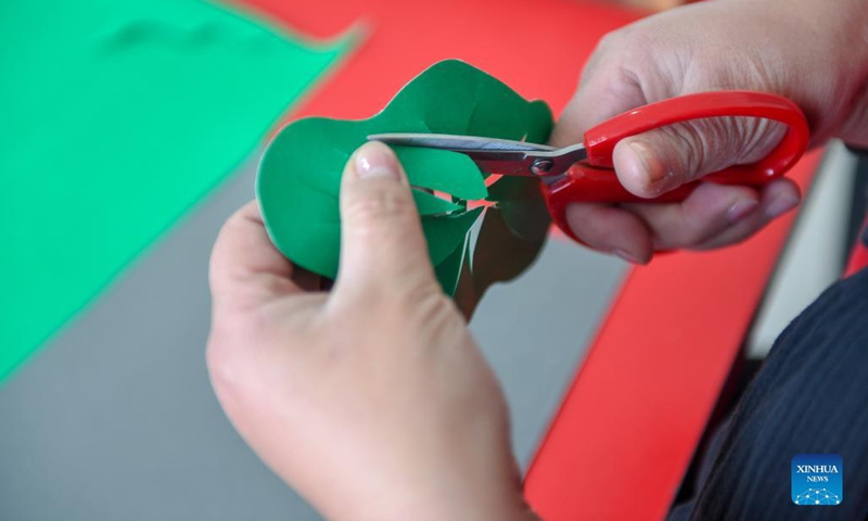 Li Baofeng creates works of paper cutting in Changchun, northeast China's Jilin Province, Dec. 17, 2021. Li Baofeng, 56, is a paper cutting artist in Jilin. Combining traditional paper cutting technique with features of various painting forms like the Chinese painting, oil painting and printmaking, Li creates her own art style. Her works are rich in color and strong in three-dimensional sense. Most of her creations focus on the Chinese classical literature, folk customs and landscape(Photo: Xinhua)
