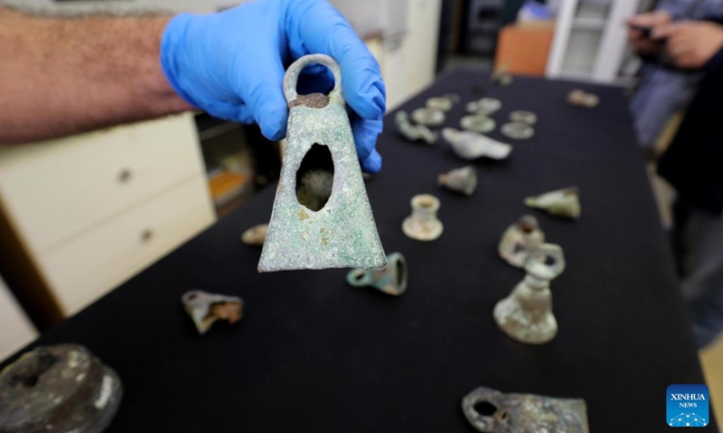 An artifact found from an ancient shipwreck in the Mediterranean Sea, is displayed at the Israel Antiquities Authority lab in Jerusalem on Dec. 22, 2021. Israeli marine archaeologists have found some rare treasure from two ancient shipwrecks in the Mediterranean Sea, the Israel Antiquities Authority (IAA) said on Wednesday.(Photo: Xinhua)