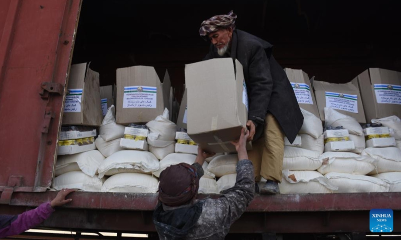 A man unloads humanitarian aid provided by Uzbekistan in Mazar-i-Sharif, Afghanistan, Dec. 23, 2021. Uzbekistan has provided 3,700 tons of humanitarian aid to war-torn Afghanistan to help needy people in the chilly winter.(Photo: Xinhua)