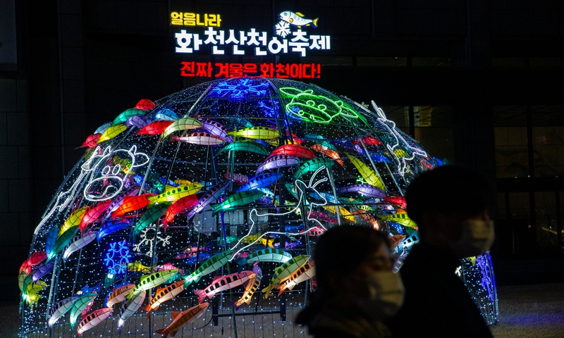 People pose for photos with Christmas decorations in downtown Seoul, South Korea, Dec. 25, 2021.Photo:Xinhua