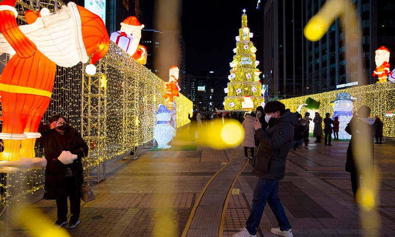 People pose for photos with Christmas decorations in downtown Seoul, South Korea, Dec. 25, 2021.Photo:Xinhua