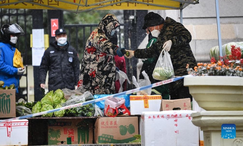 A vegetable market is set up at the entrance of a residential area under quarantine in Xi'an, northwest China's Shaanxi Province, Dec. 25, 2021.Photo:Xinhua