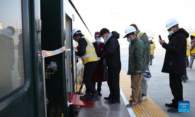 Railway constructors board the first train of the Jiuqian-Dongfeng section of Jiuquan-Ejina railway at Suzhou Railway Station in Jiuquan City, northwest China's Gansu Province, Dec. 26, 2021. (Xinhua/Chen Bin)