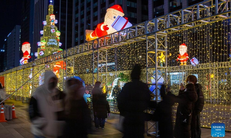 People pose for photos with Christmas decorations in downtown Seoul, South Korea, Dec. 25, 2021.Photo:Xinhua