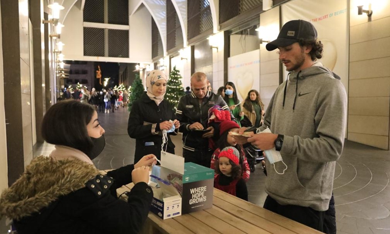 People buy face masks before entering a Christmas market in downtown Beirut, Lebanon, on Dec. 25, 2021.Photo:Xinhua