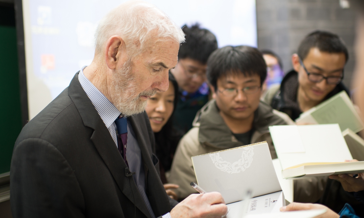 Sinologist Jonathan D. Spence signs a book for students after a lecture in Peking University in Beijing on February 28, 2014. Photo: VCG