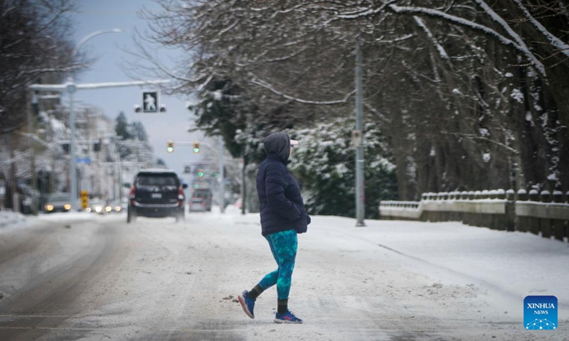 A person walks across a snow-covered street in Vancouver, British Columbia, Canada, on Dec. 26, 2021.Photo:Xinhua