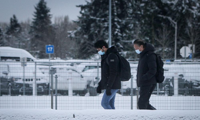 People walk on a snow-covered street in Vancouver, British Columbia, Canada, on Dec. 26, 2021.Photo:Xinhua