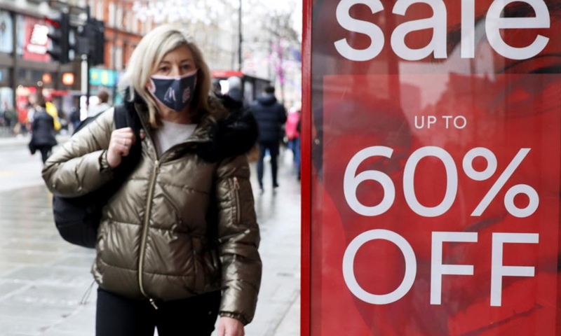A woman walks past a shop on Oxford Street on Boxing Day in London, Britain, Dec. 26, 2021. (Xinhua/Li Ying)
