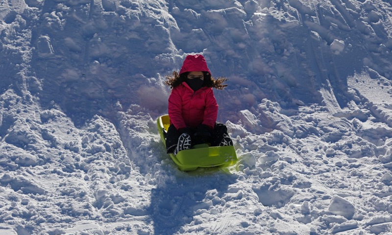 A child enjoys playing on snow in the Kfardebian region of Lebanon on Dec. 26, 2021.(Photo: Xinhua)
