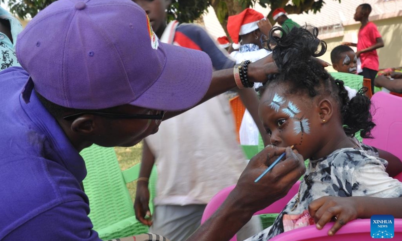 A child has her face painted during a donation ceremony in the Ashanti Region, Ghana, Dec. 26, 2021. A Ghanaian charity and several Chinese companies on Sunday donated batches of daily necessities to worse-off communities in the Ashanti Region.(Photo: Xinhua)