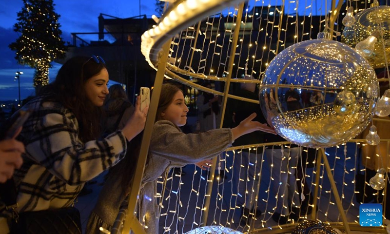 People take photos of a light installation to greet seasonal holidays in Istanbul, Turkey, Dec. 27, 2021. (Xinhua/Shadati)