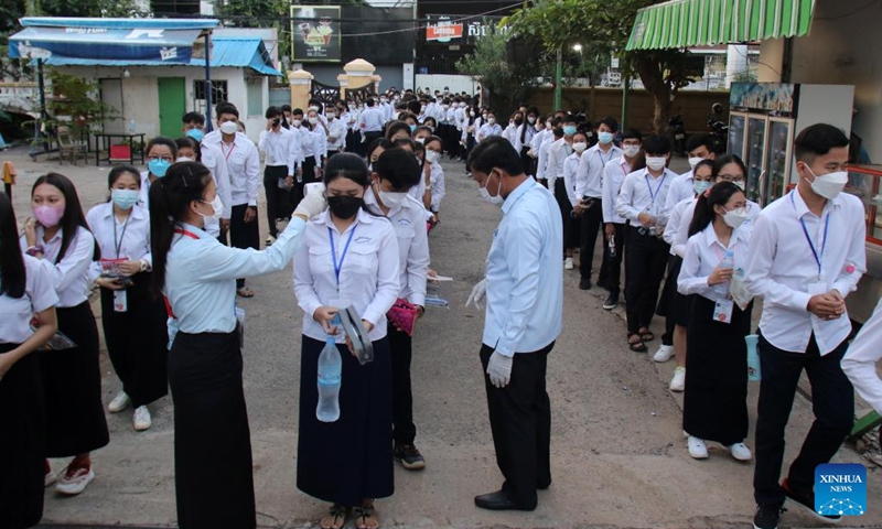 Students have their temperature checked before sitting for high school graduation exam in Phnom Penh, Cambodia on Dec. 27, 2021. A total of 114,183 Cambodian candidates took a national high school graduation exam on Monday after the COVID-19 pandemic has been brought under control. (Photo: Xinhua)