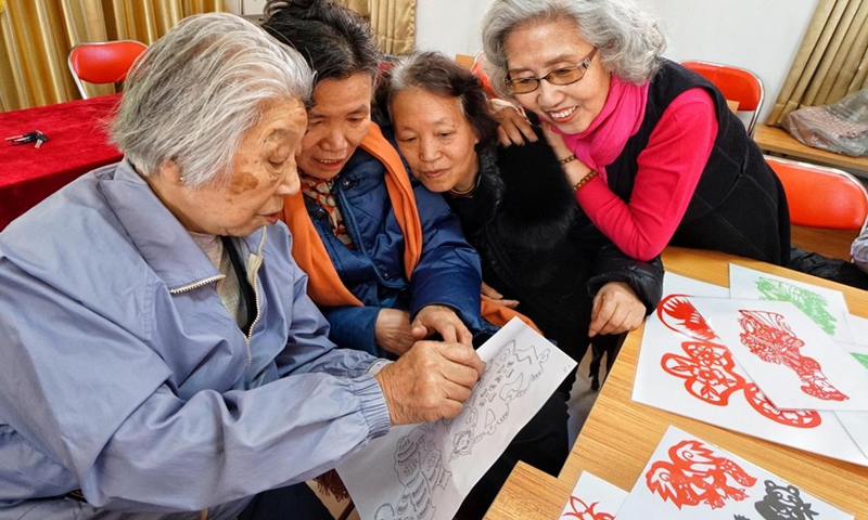 Elderly women attend a paper-cutting workshop organized by a local community in Fengtai District of Beijing, capital of China, March 8, 2018. Photo: Xinhua