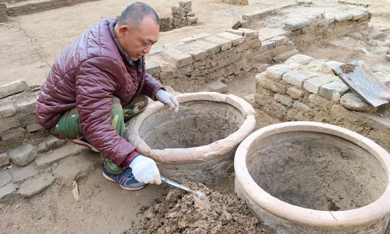 An archeologist works at an unearthed ancient winery site in Taocheng District of Hengshui, north China's Hebei Province, Nov. 16, 2021. A large scale winery site dating back to the late Ming Dynasty (1368-1644) and early Qing Dynasty (1644-1911) has been unearthed in north China's Hebei Province. Covering an area of about 3,000 square meters, pits, drying fields, underground distillation stoves and a large number of relics including ceramic pieces, metals, glass and shells were unearthed at the site.(Photo: Xinhua)