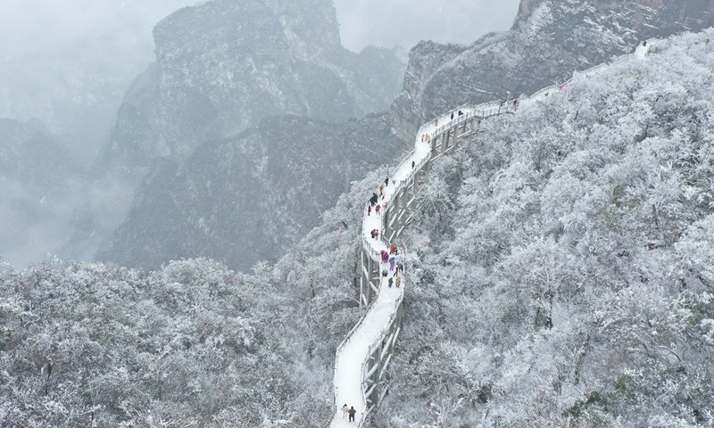 Aerial photo taken on Dec. 27, 2021 shows people visiting the snow-covered Tianman Mountain in Zhangjiajie of central China's Hunan Province.(Photo: Xinhua)