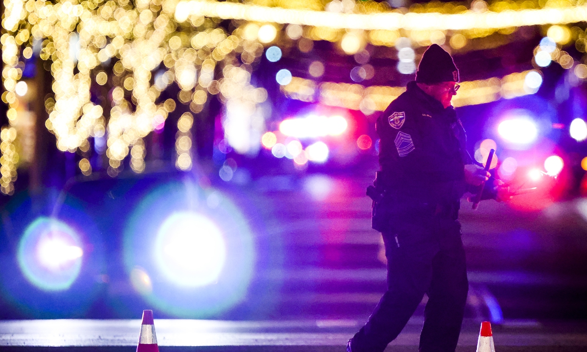 A police officer picks up flares at the Belmar shopping center where authorities say the suspect in a shooting spree that claimed five lives was shot and killed on December 27, 2021 in Lakewood, Colorado. Photo: VCG