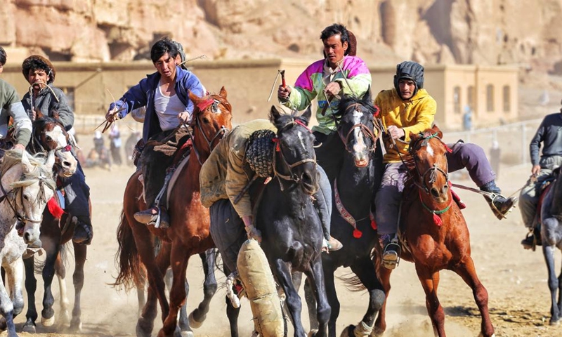 Horse riders compete during a game of Buzkashi, or goat grabbing in English, in Bamiyan, Afghanistan, Dec. 28, 2021. (Photo by Ahmadi/Xinhua)