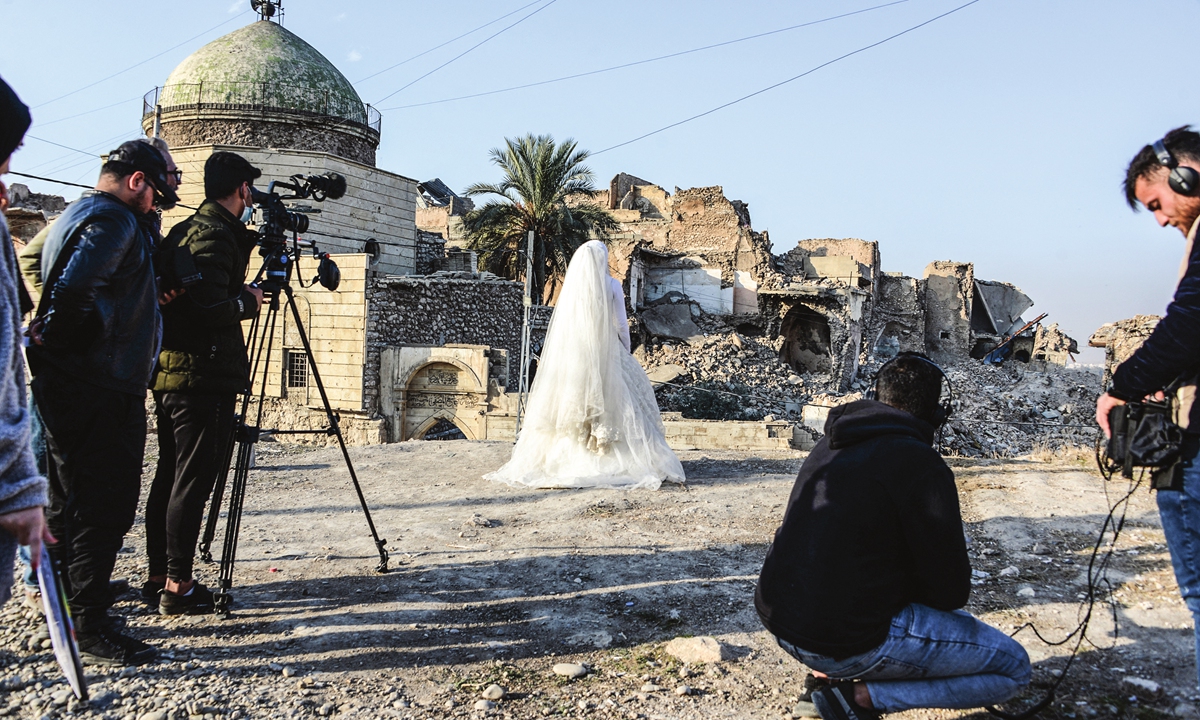 Film school students work on a scene with an actress dressed as a bride in the war-ravaged northern Iraqi city of Mosul on December 15, 2021. Photo: AFP