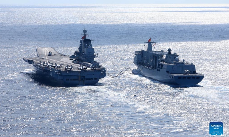 Undated file photo shows the Chinese navy's <em>Liaoning</em> (L) aircraft-carrier receiving supplies during open-sea combat training.Photo:Xinhua