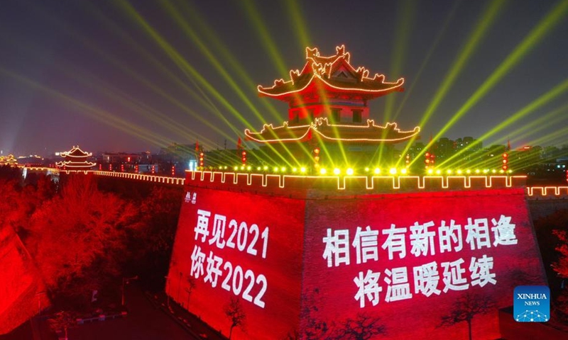 Aerial photo taken on Dec. 31, 2021 shows the ancient city wall with light and projected words to greet the New Year and pay tribute to people making efforts to fight against the recent resurgence of COVID-19 pandemic in the city of Xi'an, northwest China's Shaanxi Province.Photo:Xinhua