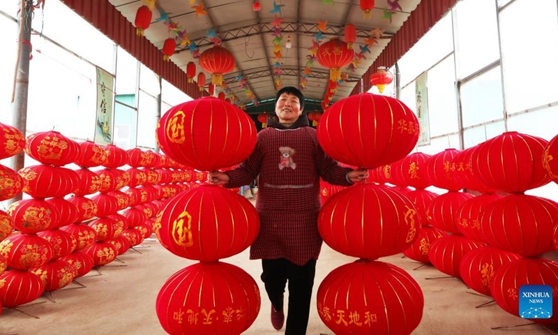 A villager carries lanterns in Benzhuang Village of Guqiao Township in Changge City, central China's Henan Province, Dec. 31, 2021.Photo:Xinhua