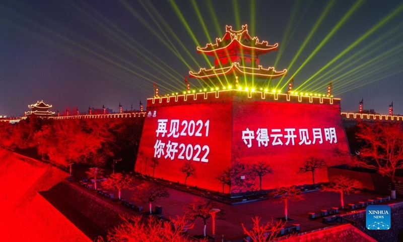 Aerial photo taken on Dec. 31, 2021 shows the ancient city wall with light and projected words to greet the New Year and pay tribute to people making efforts to fight against the recent resurgence of COVID-19 pandemic in the city of Xi'an, northwest China's Shaanxi Province.Photo:Xinhua