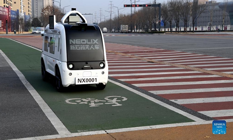 An unmanned delivery vehicle runs on a bicycle lane in Xi'an, capital of northwest China's Shaanxi Province, Jan. 9, 2022. The driverless vehicle is designed to transport goods with a maximum weight of 320 kg per trip. It can traverse 6.5 km through the lanes on roads on a single trip. (Xinhua/Tao Ming) 