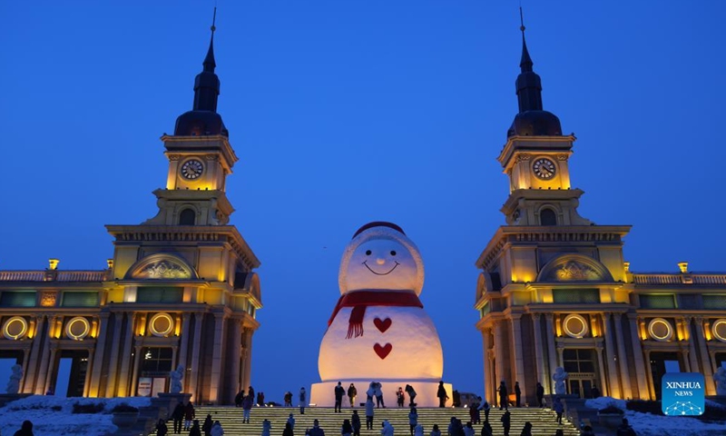 Aerial photo taken on Jan. 9, 2022 shows a huge snowman on the riverbank of Songhua River in Harbin, capital of northeast China's Heilongjiang Province. The giant snowman is about 18 meters tall and 13 meters wide, using more than 2,000 cubic meters of snow. (Xinhua/Wang Jianwei)