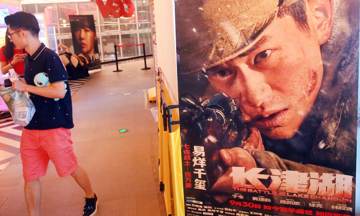 The audiences watch a film at a cinema in Shanghai on November 12, 2021. 
Top: A man walks past a poster for movie The Battle at Lake Changjin in a cinema in Shanghai on October 10, 2021. Photos: VCG
