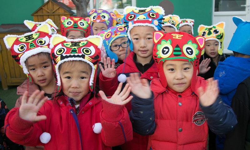 Children wearing traditional tiger hats pose for a photo at a kindergarten in Mentougou District of Beijing, capital of China, Dec. 29, 2021.Photo:Xinhua