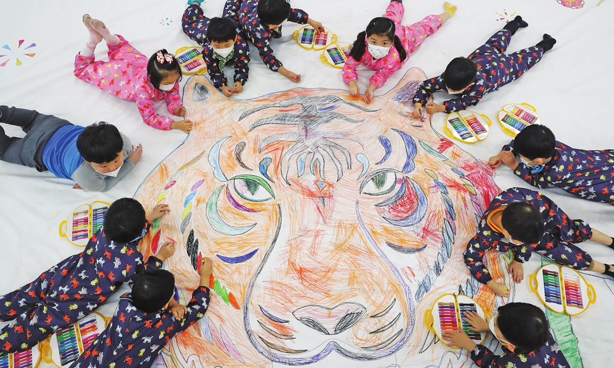 South Korean children paint a tiger on the canvas on January 5, 2022 in Gwangju to greet the coming of the Year of the Tiger. Photo: VCG