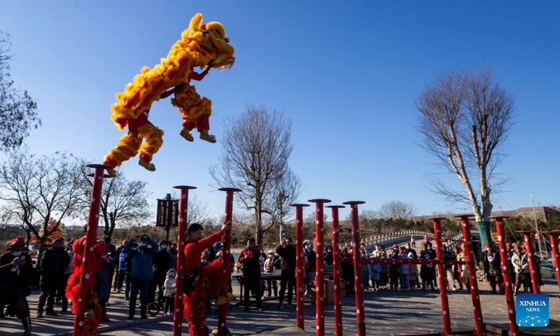 Tourists watch lion dance performance during the New Year holiday at Penglai Pavilion scenic area of Yantai, east China's Shandong Province, Jan. 2, 2022.Photo:Xinhua