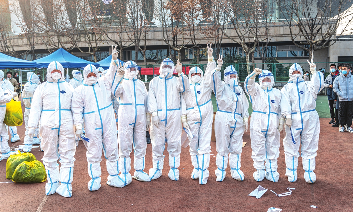 Volunteers in protective suits pose for a photo in a university in Xi'an on January 2, 2022. Photo: IC