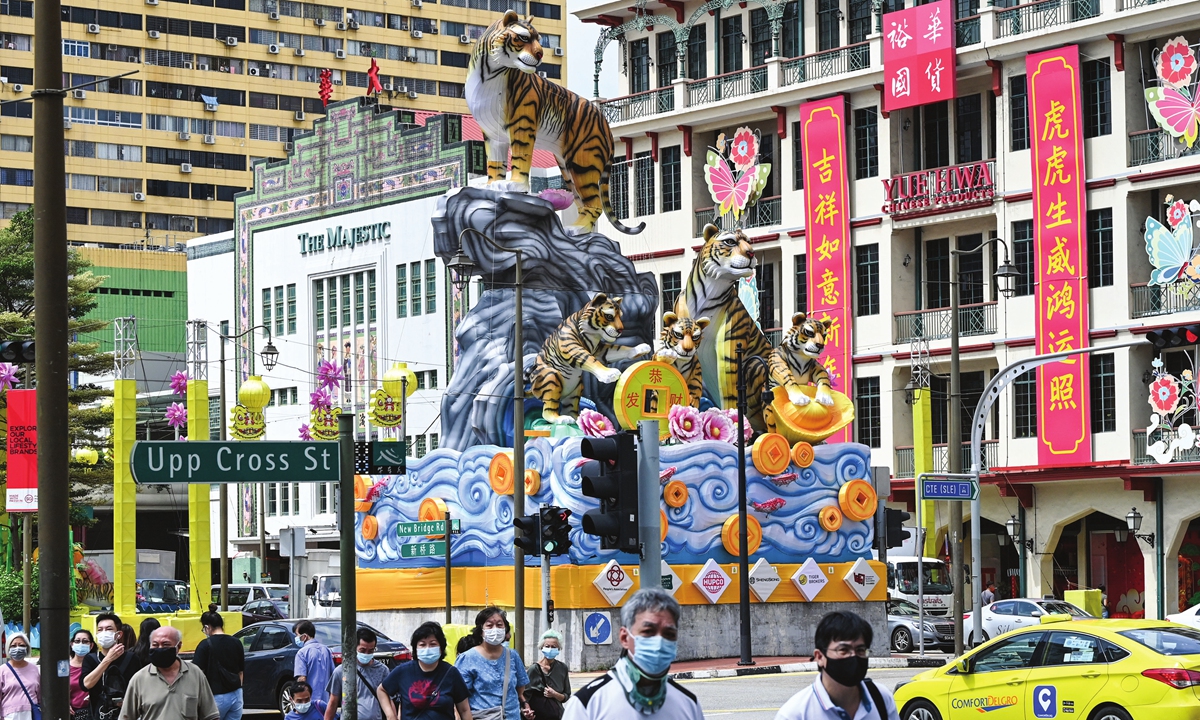 Pedestrians cross a street next to a Lunar New Year of the Tiger decoration in the Chinatown district in Singapore on January 10, 2022.  Photo: AFP