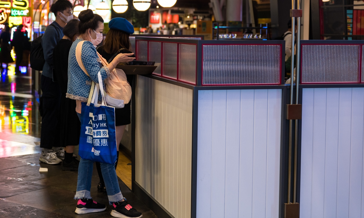A woman checks a menu outside a restaurant in Langham place, in Hong Kong, China, on January 2, 2022. Photo: VCG 
