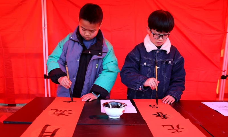 Children write couplets during the New Year holiday in Huai'an City, east China's Jiangsu Province, Jan. 1, 2022.Photo:Xinhua